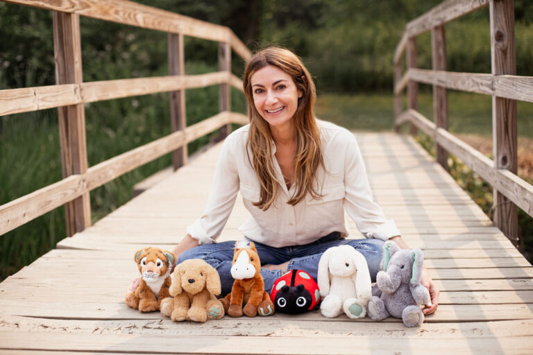 heather levine hayden on bridge with plush dolls lined up in front of her.