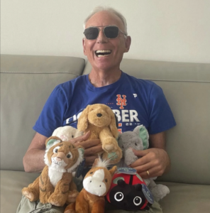 max levine, custom brand plush mareketing expert sitting on couch with plush dolls.